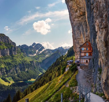 Swiss Alps and a restaurant under a cliff on mountain Ebenalp in Switzerland clipart