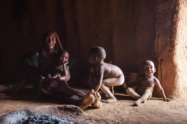 Moeder met drie kinderen van de Himba stam in Namibië spelen in hun hut — Stockfoto