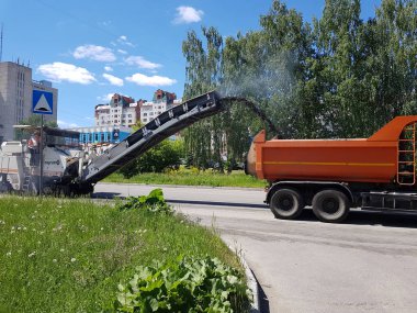 Chelyabinsk, Rusya, 29 Mayıs 2020. Şehir geliştirme programının bir parçası olarak yol onarımı, arabalar eski asfalttan yolu temizliyor.