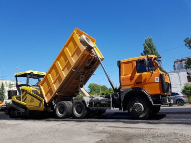 Chelyabinsk, Rusya, Haziran 06, 2020. Kentsel gelişim onarım programının bir parçası olarak yol onarımı. Arabalar yola yeni asfalt seriyorlar..