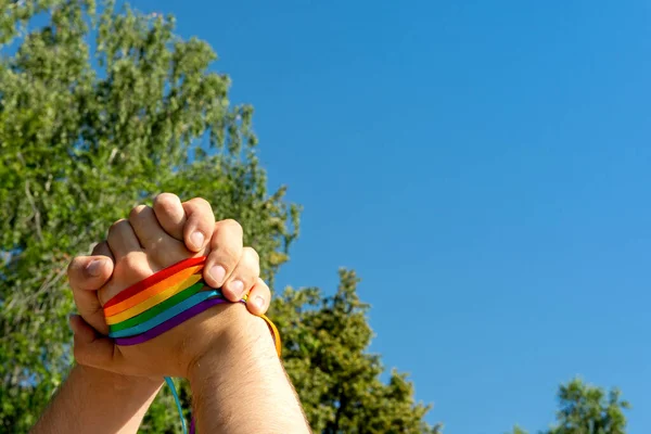 Gay gurur konsepti. Eşcinsel gururu LGBT gökkuşağı bilekliği ile el yapımı arkadaşlık ve eşitlik işareti