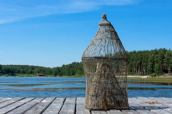 Pułapka na ryby na drewnianym pomoście na brzegu jeziora — Zdjęcie stockowe