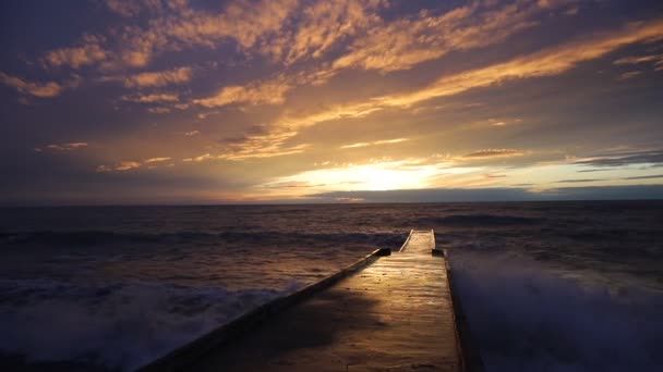在日落的背景下出海的混凝土码头 海洋娱乐的概念 太阳落在海里 海浪冲击着码头 — 图库视频影像