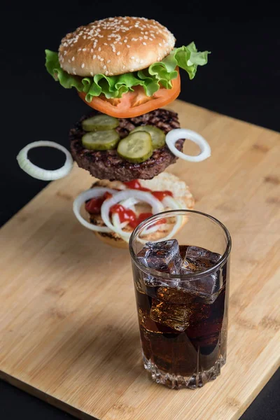 Deliciosa Hamburguesa Con Ingredientes Flotantes Fondo Una Mesa Madera Pan — Foto de Stock