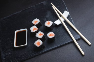 Siyah arka planda suşi. Suşi restoranı menüsü yapmak için mükemmel. Japon mutfağı, Doğu kültürü.