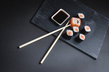 Siyah arka planda suşi. Suşi restoranı menüsü yapmak için mükemmel. Japon mutfağı, Doğu kültürü.