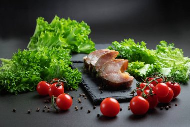 Soğuk Tütsülenmiş balık dilimleri. Kapat. Balık ve sebzelerle dolu bir hayat. Koyu bir arka planda yemek.