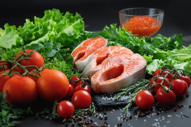 Taş tabakta kırmızı balık. Deniz ürünleri ve sebzelerle dolu bir hayat. Karanlık bir arka planda deniz ürünleri. Balık ve alkol. Kırmızı havyar. Şişedeki Rus votkası..