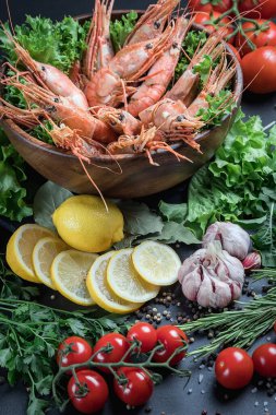 Büyük karidesler, ahşap bir tabakta yatıyorlar. Deniz ürünleri tabağı. Kremalı sosla sotelenmiş karides. Salata yeşili..