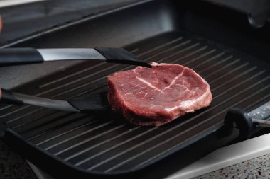 Çiğ Angus bifteği, dökme demir bir tavada kızartılmış. Kızartma tavası..