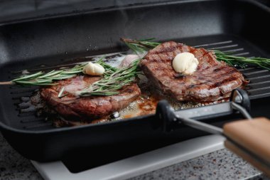 Izgarada pişmiş taze et. Et tereyağında kızarır. Biberiyeli biftek. Etteki şeritler. Kızartma tavası..