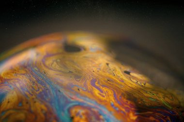 Siyah arkaplanlı renkli sabun köpüğü.