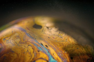 Siyah arkaplanlı renkli sabun köpüğü.