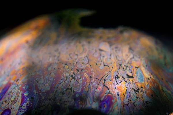 Siyah arkaplanlı renkli sabun köpüğü.