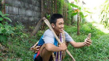 Asyalı adam cep telefonuna bakarken mutlu.