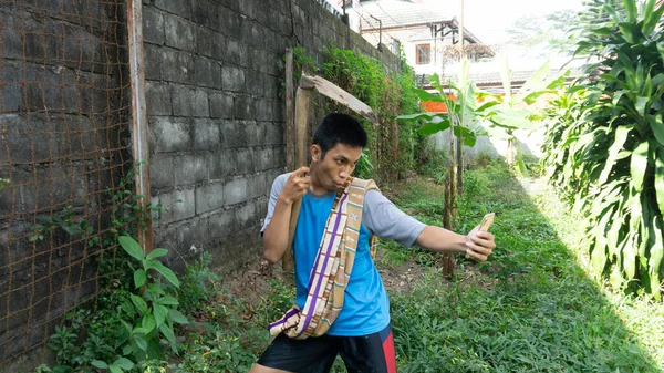 Aziatisch Man Tuinieren Kijken Naar Een Mobiele Telefoon Met Een — Stockfoto