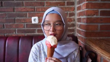 Gelato dondurmasının tadını çıkarırken Asyalı tesettürlü kız