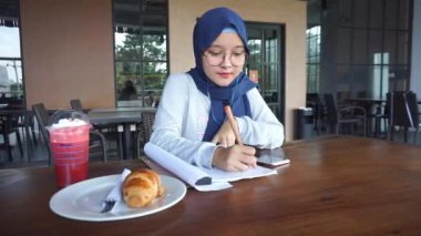 Asyalı iş kızı not alıyor.