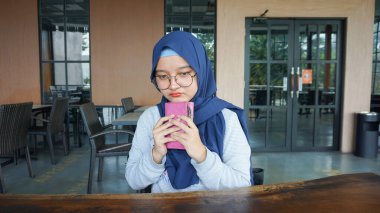 Asyalı kadın boş bir cüzdan görünce üzülüyor.