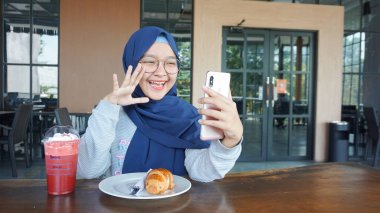 Asyalı tesettürlü kadın bir video konferansında.