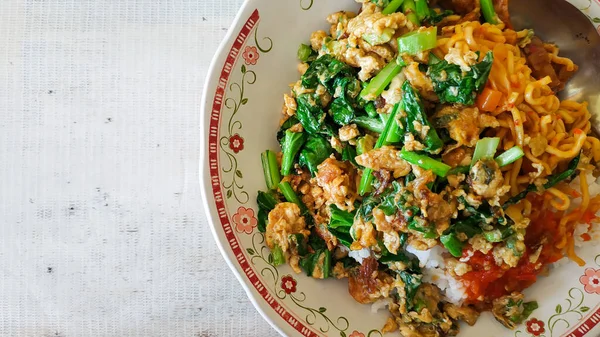 Nasi Orak-Arik ya da çırpılmış pirinç, Waroong 'da burjo denilen sokak yemeği.