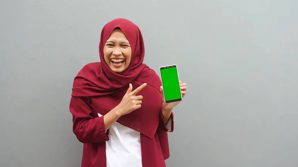 Азиатка Указывает Сотовый Телефон Зеленым Экраном — стоковое фото
