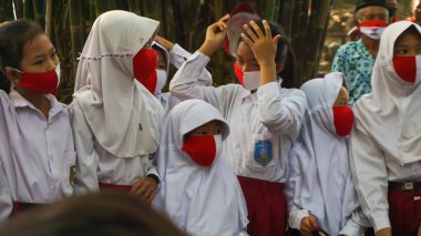 9 Ağustos 2020, Yogyakarta, Endonezya: Endonezyalı çocuklar ilkokul kıyafetleri giyip maske takıyorlar