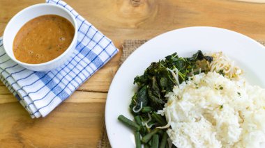 Nasi Pecel. Geleneksel Java pirinç tabağı, sebze salatası, fıstık sosu, tempeh, fasulye ezmesi ve kraker..