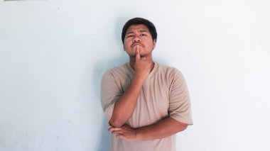 Bir şey düşünüp, fikir üreten şişman Asyalı adam.