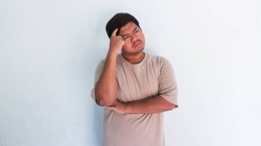 Bir şey düşünüp, fikir üreten şişman Asyalı adam.