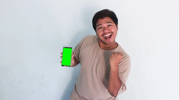 Азійський Товстун Вказує Мобільний Телефон Зеленим Екраном — стокове фото