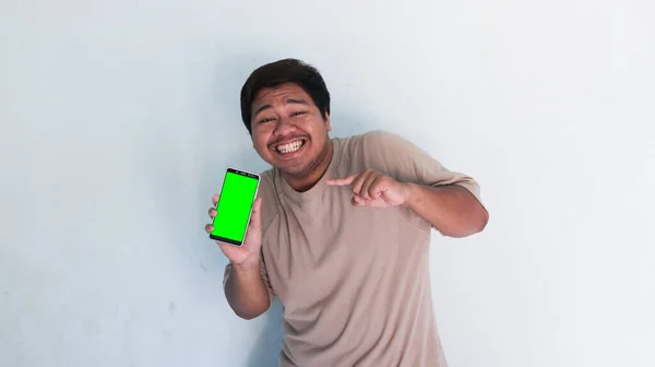 Asiatischer Dicker Mann Zeigt Auf Das Handy Mit Grünem Bildschirm — Stockfoto