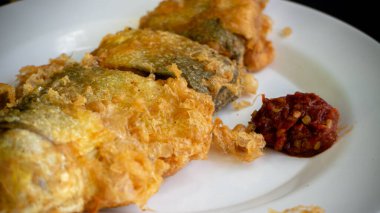 Bandeng Presto Goreng. Geleneksel mezelerle servis edilen kızartılmış yumuşak kemikli sütçü balığı.
