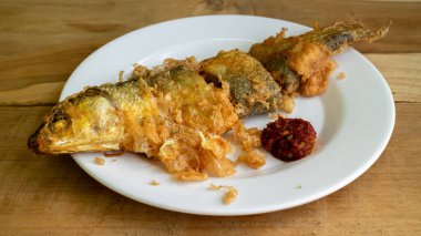 Bandeng Presto Goreng. Geleneksel mezelerle servis edilen kızartılmış yumuşak kemikli sütçü balığı.