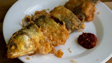 Bandeng Presto Goreng. Geleneksel mezelerle servis edilen kızartılmış yumuşak kemikli sütçü balığı.