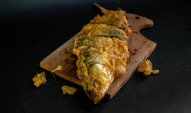 Bandeng Presto Goreng. Geleneksel mezelerle servis edilen kızartılmış yumuşak kemikli sütçü balığı.