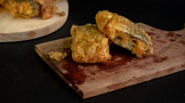 Bandeng Presto Goreng. Geleneksel mezelerle servis edilen kızartılmış yumuşak kemikli sütçü balığı.