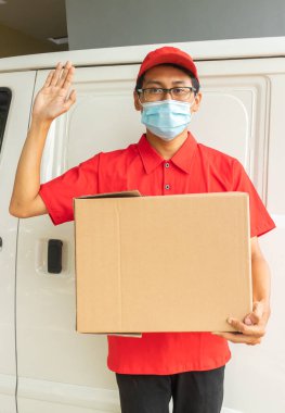 Asyalı genç adam kırmızı üniformalı, paketli ve harika elli.