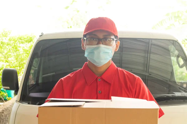 Asian young man delivery in red uniform with packages