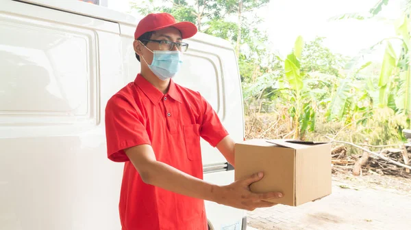 Asian young man delivery in red uniform with packages