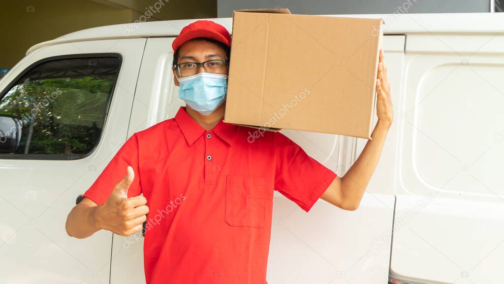 Asian young man delivery in red uniform with packages and OK expression