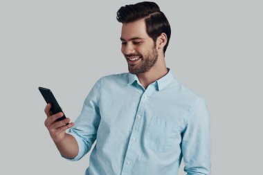 Arkadaşınıza mesaj yazarak. Yakışıklı genç adam kullanarak akıllı telefon bir