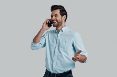 İyi konuşmalısın. Telefonda konuşan ve gülümseyen yakışıklı genç adam w