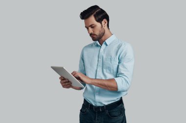 İşleri bitirmeye. Digita kullanarak çalışan konsantre genç adam