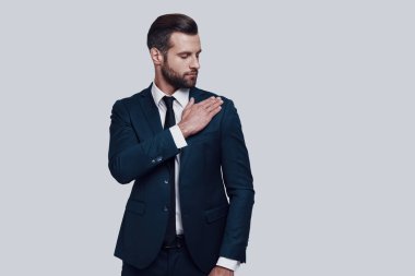 Her şey mükemmel olmalı. Gri arka planda ayakta iken yakışıklı genç adam temizlik ceket