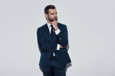 Düşüncelerimi kaybettim. Gri arka plana karşı ayakta iken çekici genç adam çene üzerine el tutarak ve gülümseyen