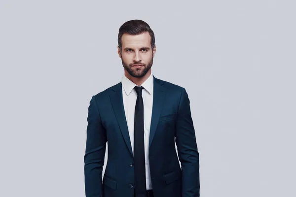 Un hombre perfecto. Guapo joven mirando a la cámara mientras está de pie sobre fondo gris — Foto de Stock