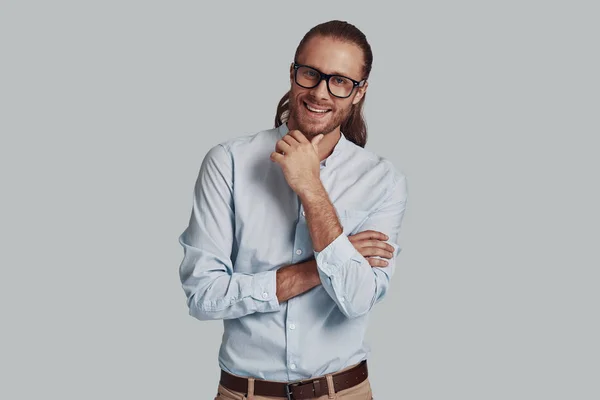 Fiducioso nel suo stile. bello giovane uomo guardando fotocamera mentre in piedi su sfondo grigio — Foto Stock