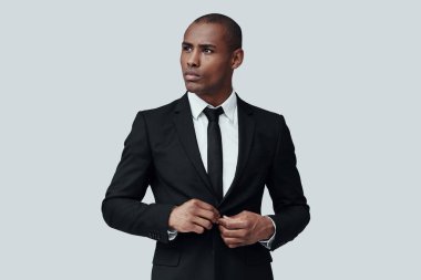 Her zaman mükemmel. Gri arka plan aleyhine dururken formalwear düğmeceket yakışıklı genç Afrikalı adam