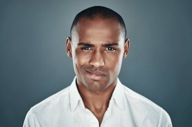 Çok çekici. Gömlek yakışıklı genç Afrikalı adam kameraya bakıyor ve gri arka plan karşı dururken gülümseyerek